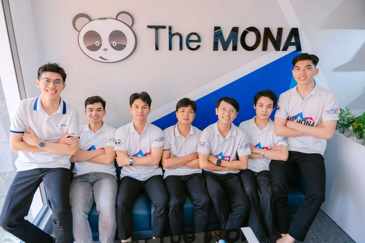 Đội ngũ The MONA ngồi trước logo công ty